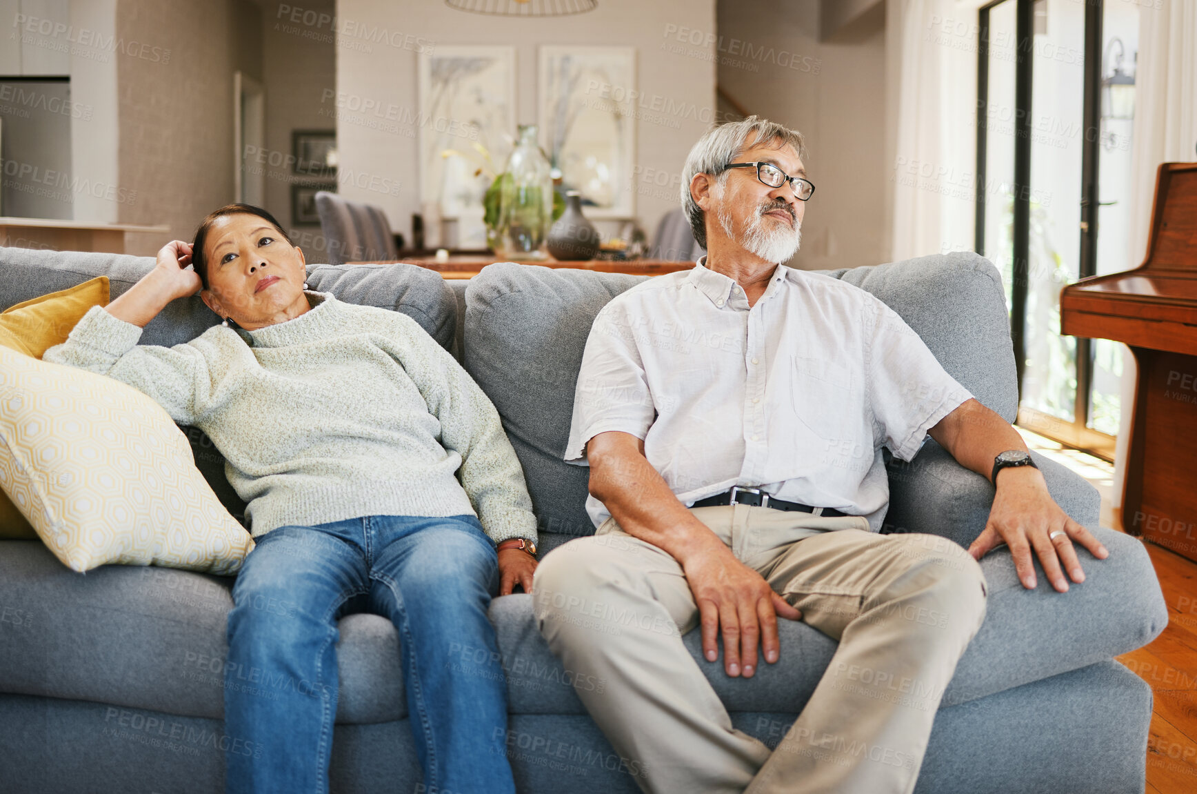 Buy stock photo Senior couple, angry and sofa in home living room, thinking or frustrated face for conflict in retirement. Elderly Asian man, old woman and stress on couch with silence, argument or fight in house