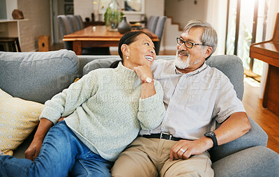 Buy stock photo Smile, happy and senior couple on a sofa bonding, talking and relaxing together in living room. Romance, love and elderly man and woman in retirement in conversation by modern lounge at home.