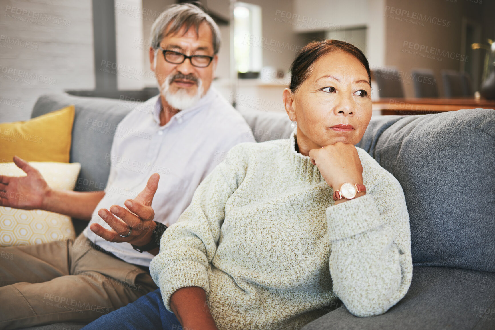 Buy stock photo Divorce, fight and mature couple on sofa, conflict and marriage crisis in home. Asian man, woman and argument in living room, stress and angry at relationship fail, frustrated people together and sad