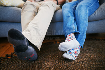 Buy stock photo Legs, feet in socks and a couple on a sofa in the living room of their home together closeup to relax. Love, relationship and bonding with people in their house for a break on weekend in winter