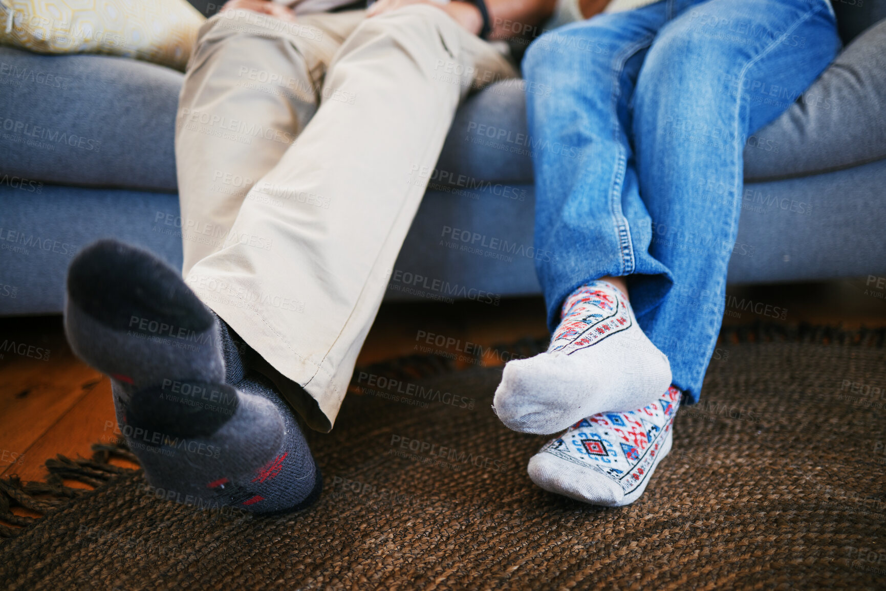 Buy stock photo Legs, feet in socks and a couple on a sofa in the living room of their home together closeup to relax. Love, relationship and bonding with people in their house for a break on weekend in winter