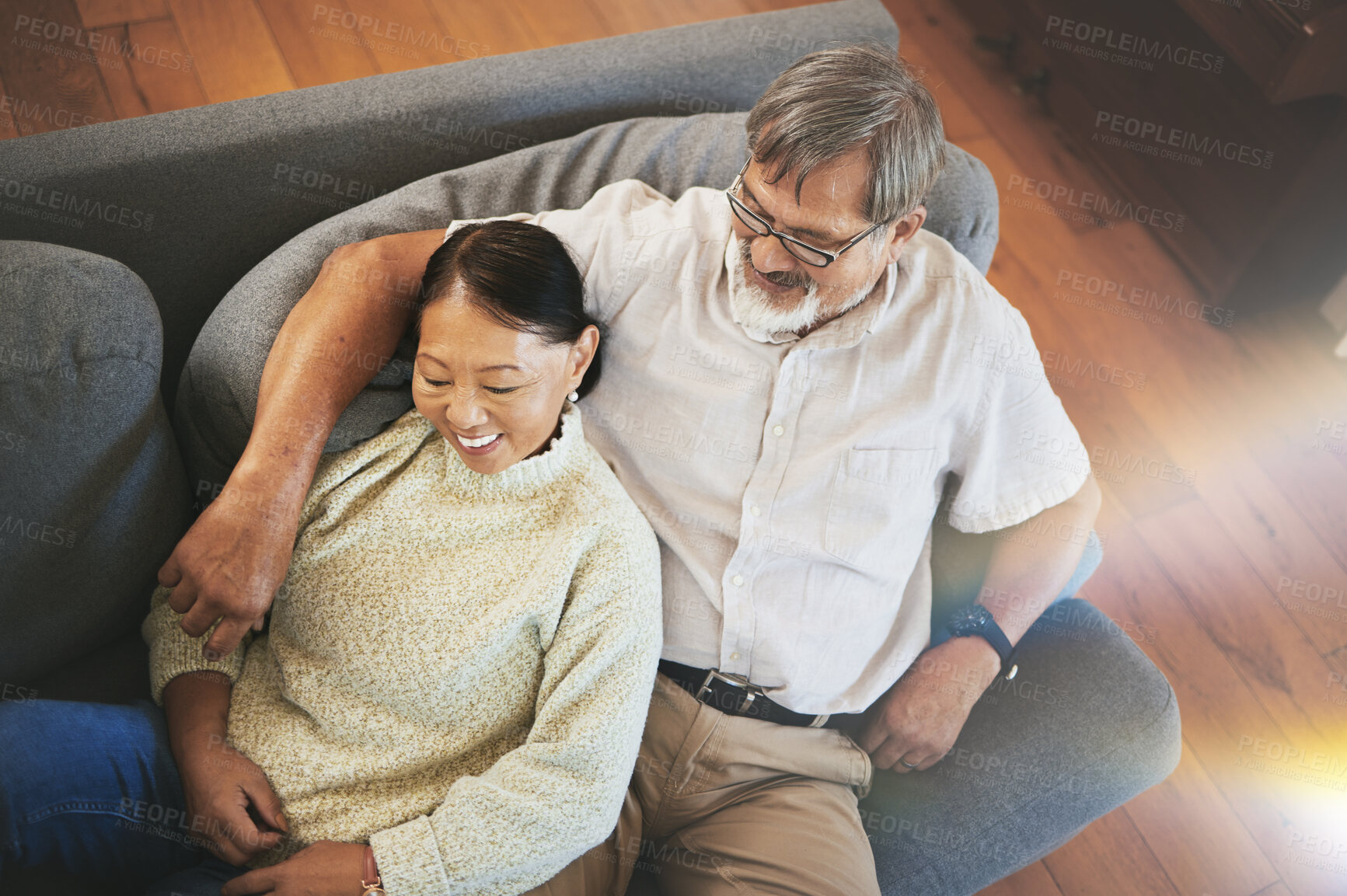 Buy stock photo Relax, love and senior couple on a sofa hugging, bonding and laying together in the living room. Happy, smile and elderly man and woman in retirement resting on a weekend in the lounge at modern home