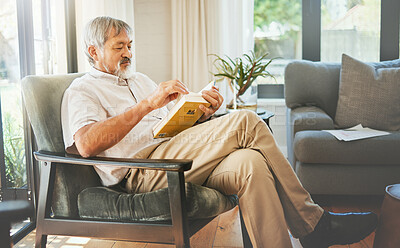 Buy stock photo Relax, book and a senior asian man reading on a chair in the living room of his home during retirement. Study, learning and elderly person pensioner in his house alone for a literature leisure hobby