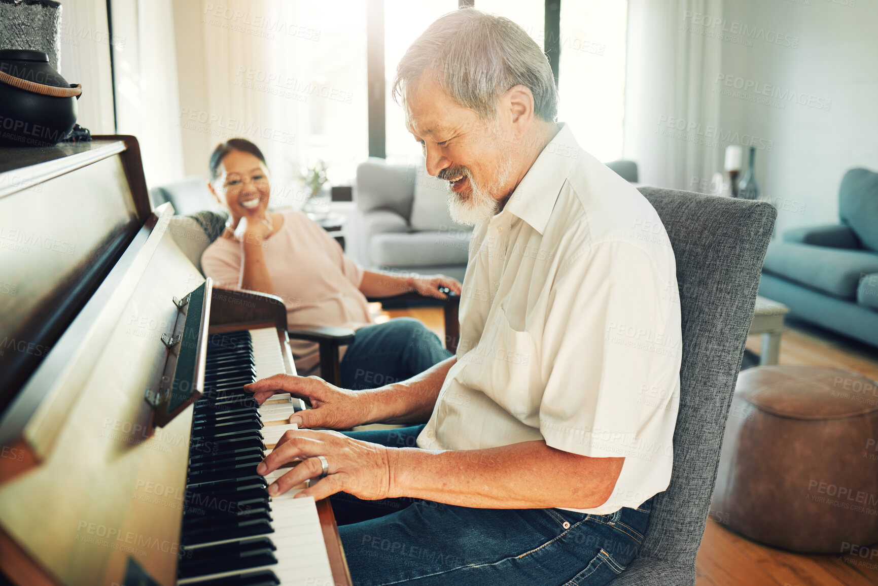 Buy stock photo Senior man playing piano for music in living room with wife for bonding, entertainment or having fun. Happy, smile and elderly Asian couple in retirement enjoying keyboard instrument at modern home.