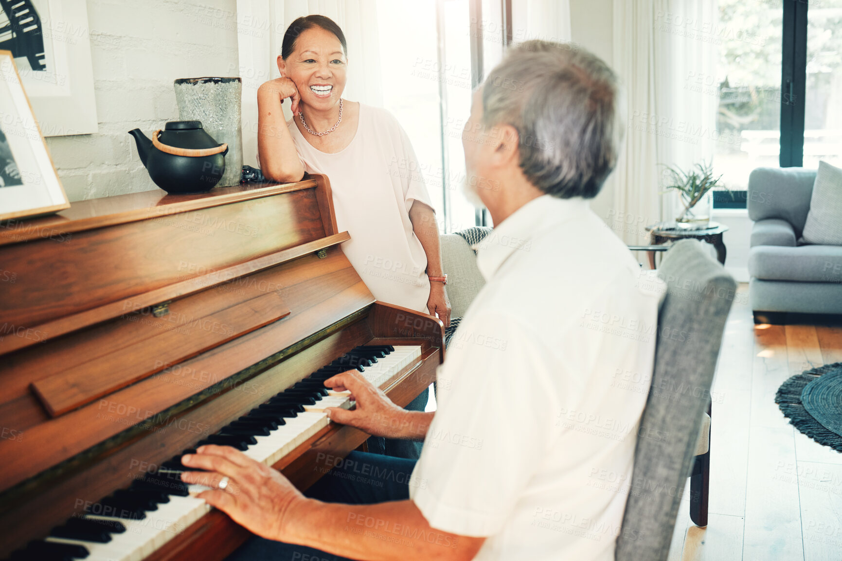 Buy stock photo Happy woman, piano or senior man playing a song or music for wife in living room with bonding or entertainment. Smile, keyboard or mature Asian couple in retirement enjoy instrument at modern home