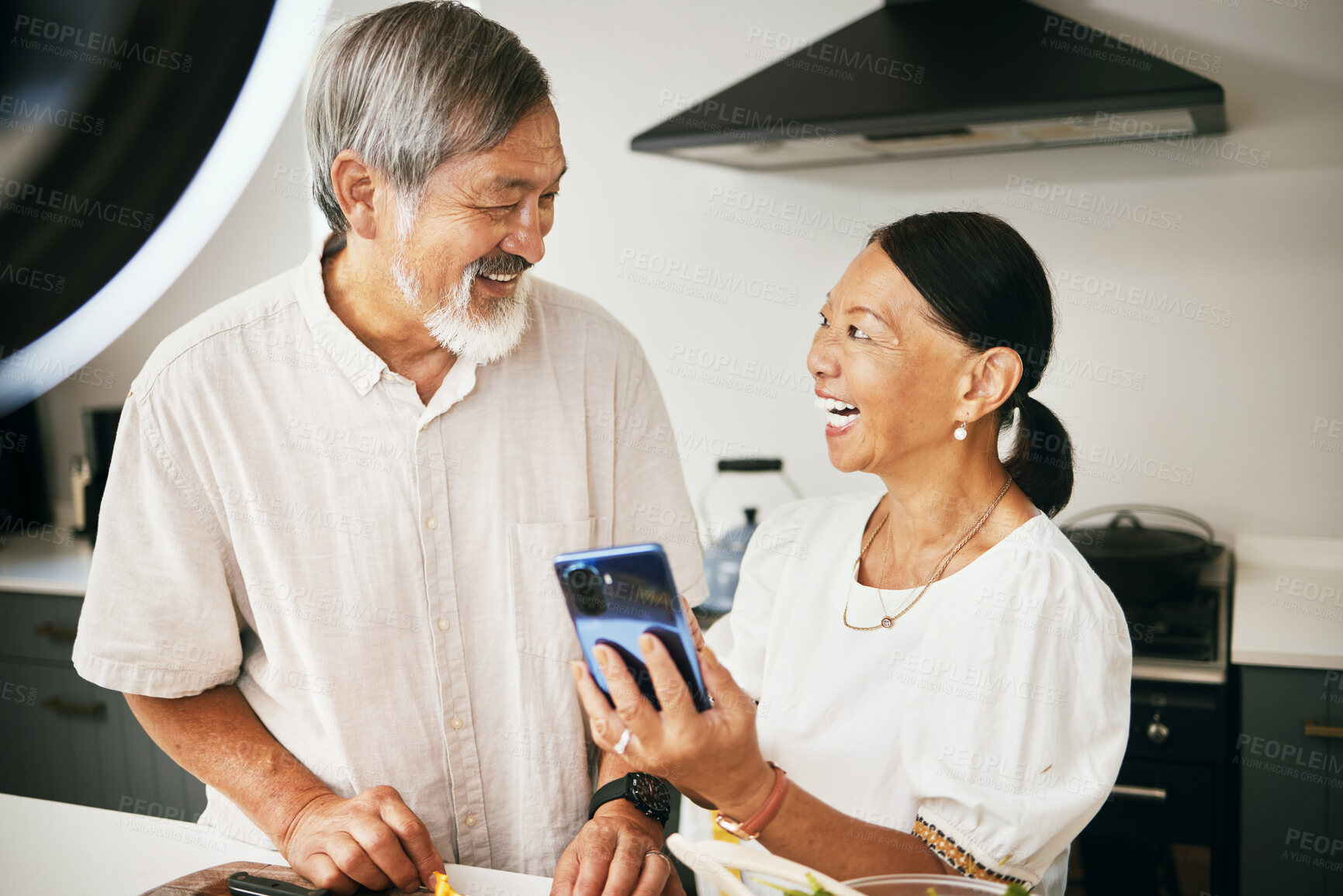 Buy stock photo Home, influencer and senior couple with a smartphone, social media and connection with conversation. Kitchen, elderly man or old woman with a cellphone, content creation and digital app with internet