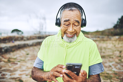 Buy stock photo Phone, headphones and senior man hiking for health, wellness or cardio training on a mountain. Smile, cellphone and elderly male person scroll on the internet for music for outdoor trekking in woods.