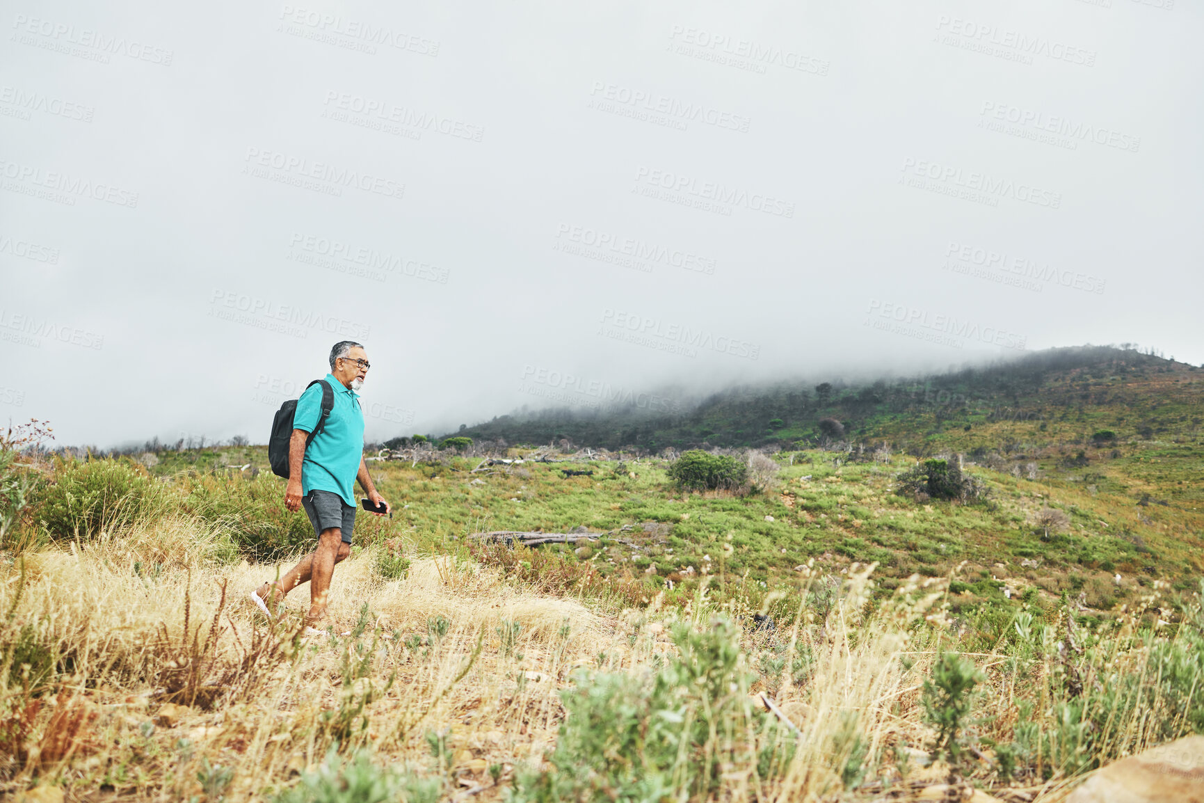 Buy stock photo Old man, hiking with nature and fitness, travel and walking in field or bush for health and wellness outdoor. Adventure, trekking and exercise, mockup space and freedom with retirement activity