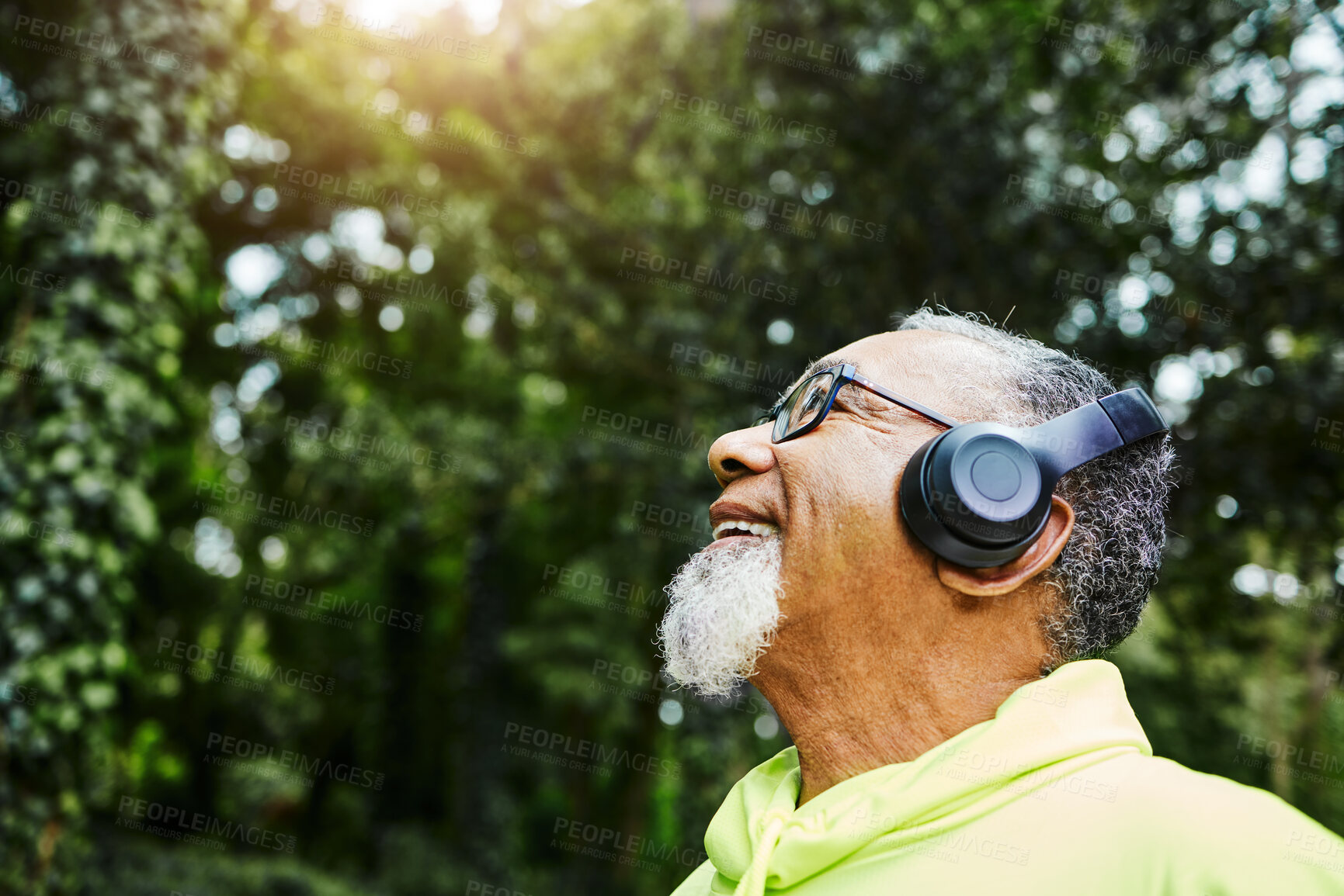 Buy stock photo Headphones, nature and senior man hiking for health, wellness or cardio training on a mountain. Smile, happy and excited elderly male person breathing for outdoor trekking in the woods or forest.