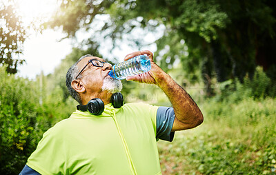 Buy stock photo Senior man, fitness and drinking water in nature for hydration or natural sustainability after workout. Mature male person with mineral drink from exercise, training or cardio in recovery or break