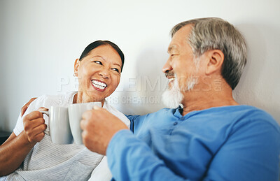 Buy stock photo Senior, coffee or happy couple in bedroom at home bonding or talking in marriage together. Cheers, drinking morning tea or Asian woman laughing with a romantic old man in retirement to relax