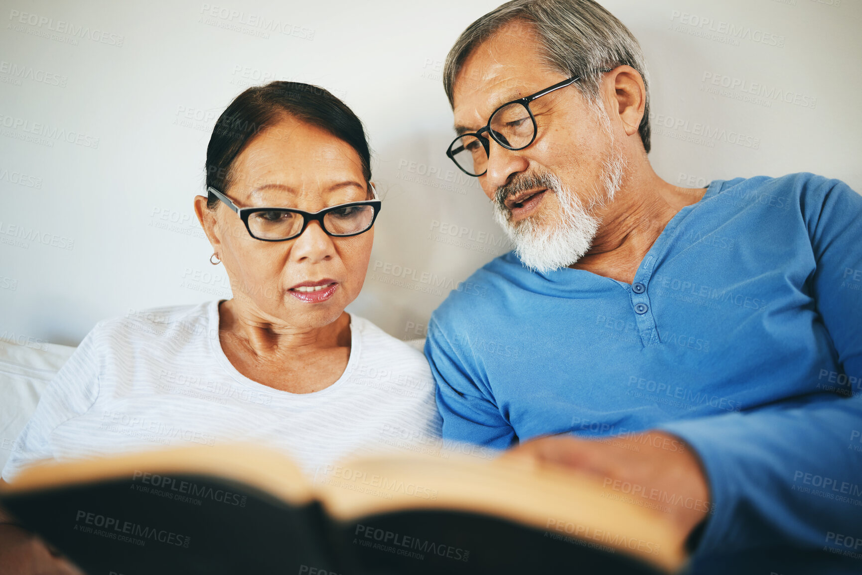 Buy stock photo Bible, home or senior couple reading book for prayer, support or hope in bed to worship together. Education, Asian man or mature woman learning or studying God for grace in religion with love or care