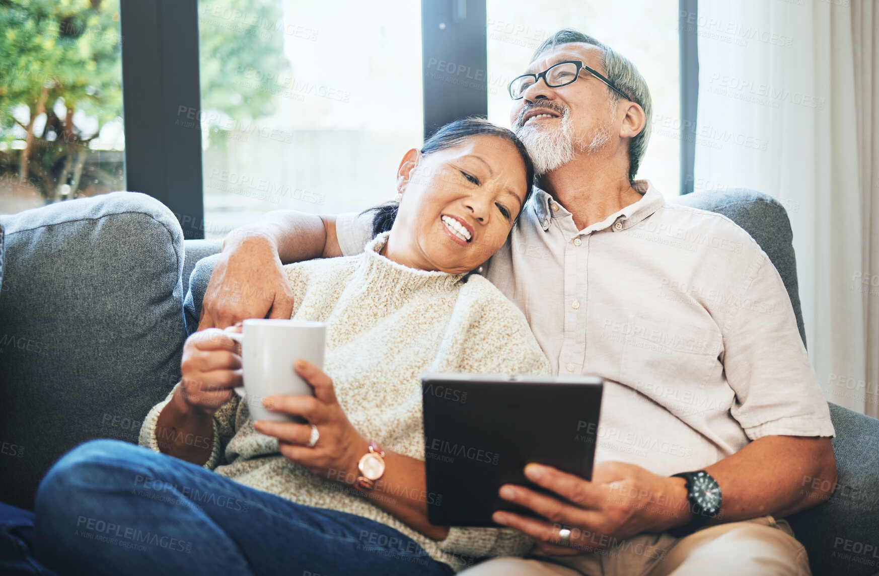 Buy stock photo Tablet, coffee and senior couple on sofa bonding, relaxing and networking on social media together. Happy, digital technology and elderly man and woman in retirement scroll on mobile app or internet.