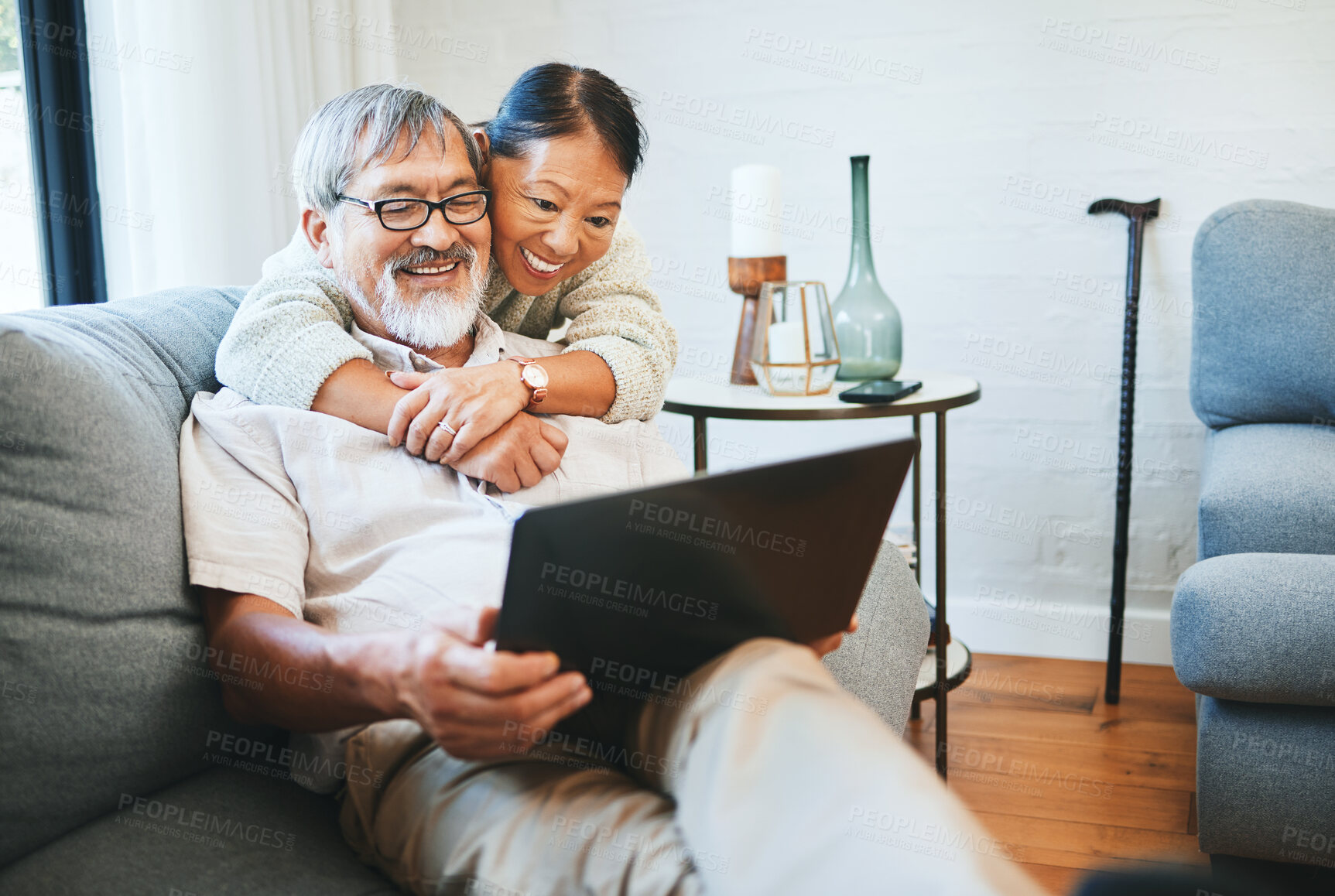 Buy stock photo Laptop, happy and senior couple on a sofa watching movie, show or film together in living room. Smile, technology and elderly man and woman in retirement streaming a video on computer at modern home.