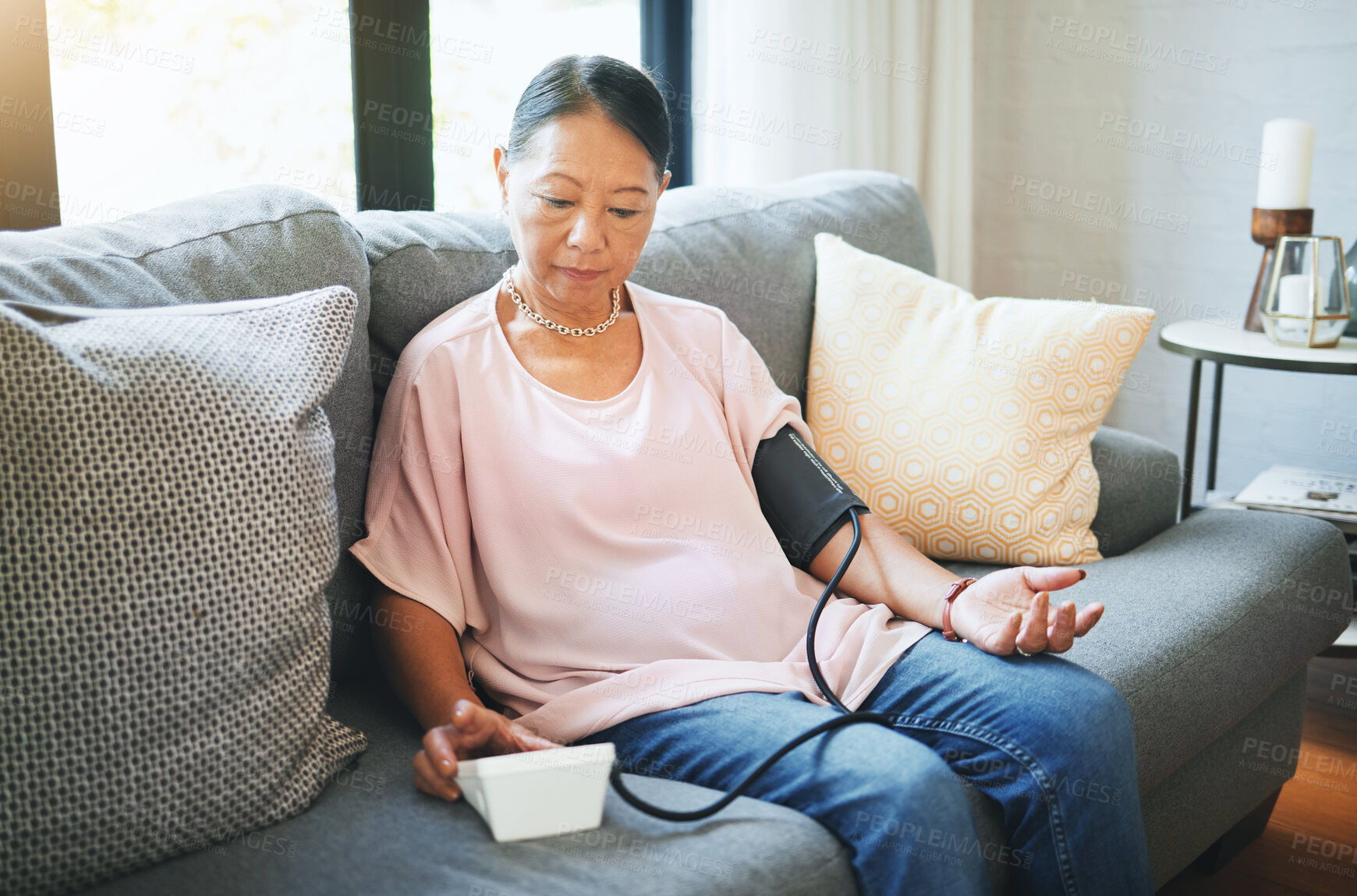 Buy stock photo Blood pressure, healthcare and senior woman in living room with equipment for hypertension. Sick, illness and elderly female person in retirement with medical tool in the lounge of modern home.