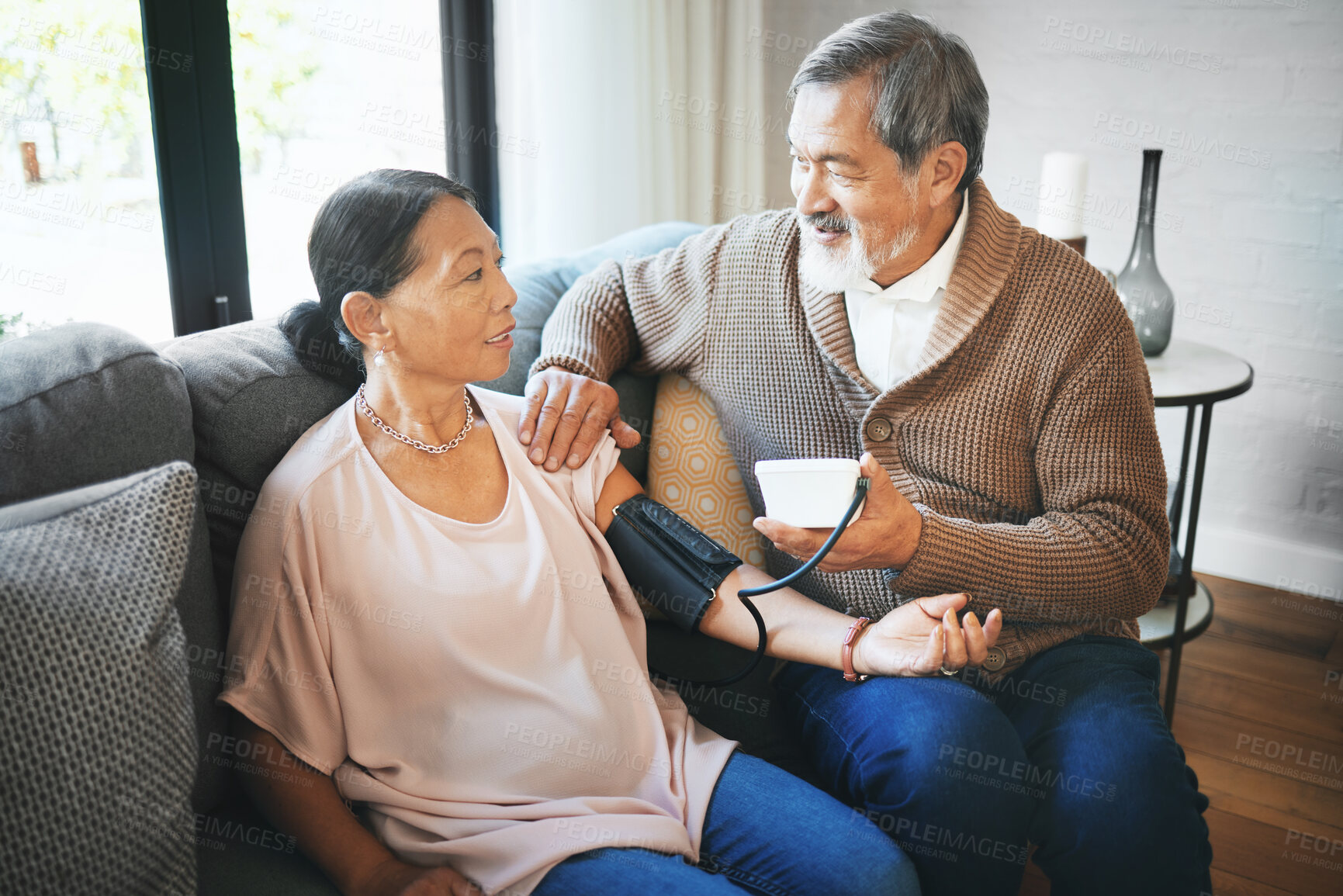 Buy stock photo Hypertension, healthcare and senior couple in living room with equipment for blood pressure. Sick, love and elderly man with medical tool for woman in retirement in the lounge of modern home together