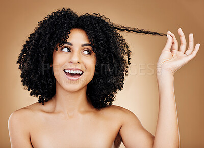 Buy stock photo Curly hair, strand and woman in studio for beauty, healthy growth or natural coil textures on brown background. Happy model pull afro hairstyle for salon aesthetic, keratin treatment or cosmetic care