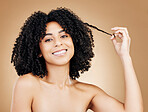 Portrait, woman and pull hair for curly beauty, natural growth and coil texture in studio on brown background. Happy model, afro hairstyle and strand for salon aesthetic, healthy treatment and shine