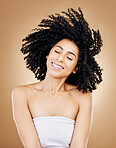 Hair, shake curls and wind, woman with beauty and treatment for shine, cosmetic care and smile on studio background. Wellness, haircare and growth with strong texture and curly locks, volume and afro