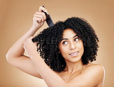 Buy stock photo Hair care, afro and woman with a comb, beauty and treatment on a brown background. Person, girl and model with salon grooming, volume or shine with glow, wellness and aesthetic with texture and clean