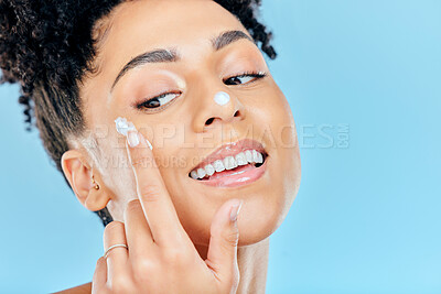 Buy stock photo Happy woman, face and cream for skincare, beauty or cosmetics against a blue studio background. Closeup of female person smile with moisturizer, creme or lotion for spa or facial treatment on mockup