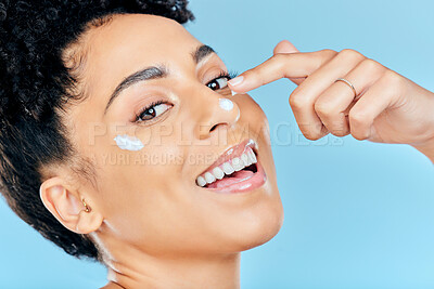 Buy stock photo Beauty skincare, portrait and happy woman with cream application of dermatology product for pimple, acne or spots prevention. Face makeup, studio cosmetics or aesthetic person on blue background