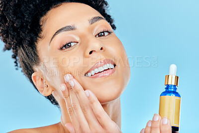 Buy stock photo Beauty serum, portrait and woman with bottle, container and apply collagen, essential oil or retinol for skin hydration. Cosmetics face product, facial skincare and studio person on blue background