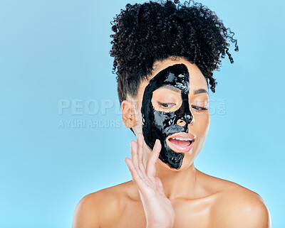 Buy stock photo Skincare, charcoal mask and woman in studio for facial treatment, anti aging detox and wellness. Beauty, salon and face of person with product for health, cosmetics or grooming on blue background