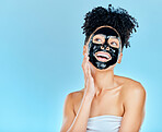 Skincare, happy and woman with charcoal face mask for facial treatment, anti aging and wellness in studio. Beauty, dermatology and happy person for health, cosmetics or grooming on blue background