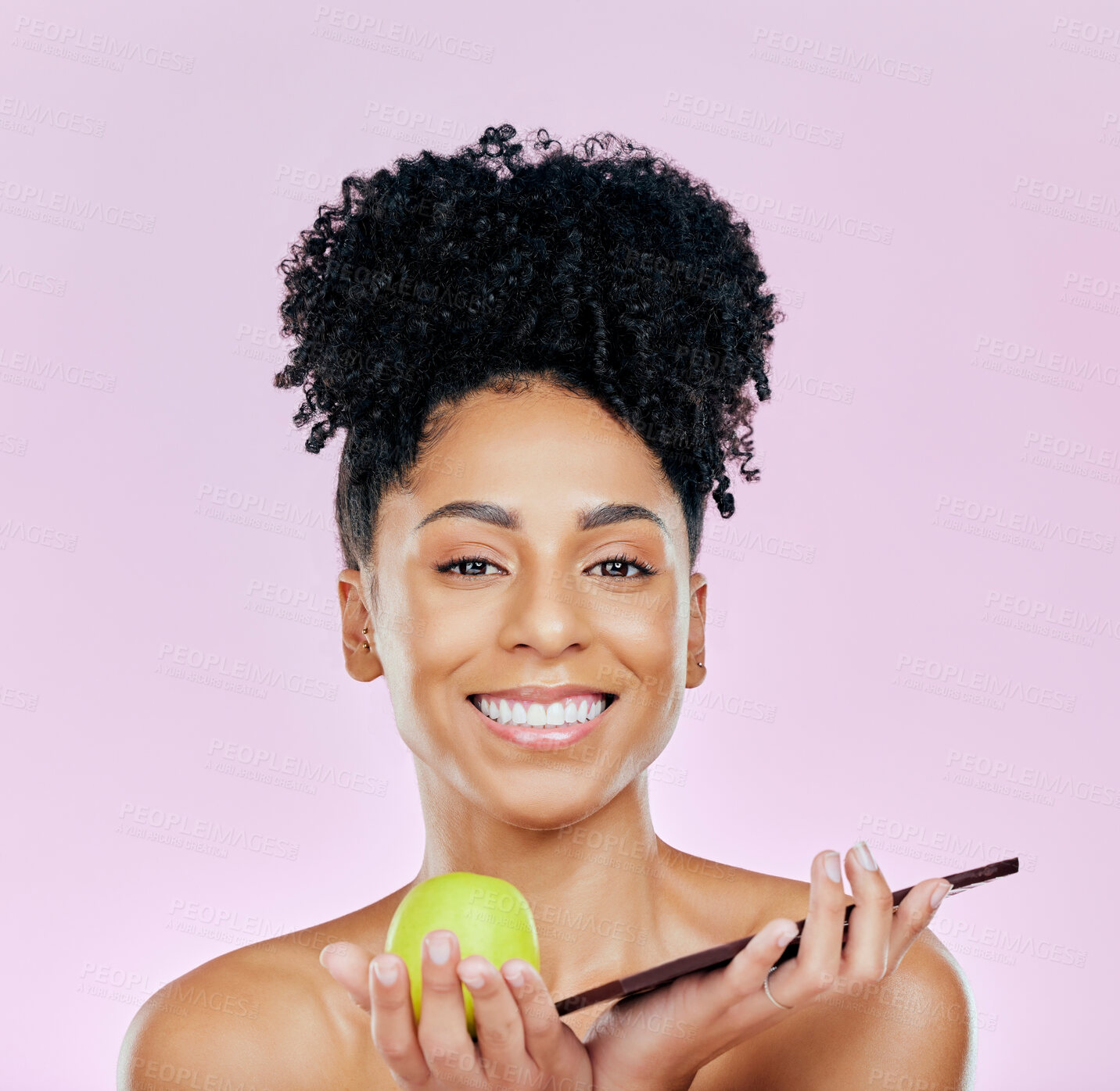 Buy stock photo Portrait of happy woman in studio with apple, chocolate and choice for food, wellness and nutrition. Fruit vs sweets, diet and decision for model on pink background with challenge for healthy eating.