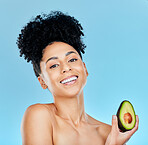 Happy woman, portrait and avocado for natural beauty, skincare or diet against a blue studio background. Face of female person smile with organic vegetable for nutrition, vitamin C or skin wellness