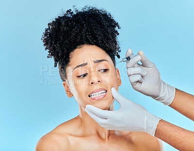 Buy stock photo Filler, fear and woman with hands on face in studio for collagen skincare injection or implant. Model with stress, anxiety and syringe for beauty, dermatology or cosmetic process on blue background.