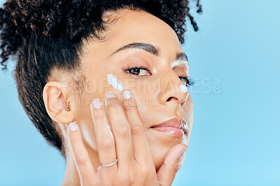 Buy stock photo Beauty, studio portrait and woman with cream application of ointment, lotion or creme for skin hydration, wellness or skincare. Melasma treatment, face acne protection and model on blue background