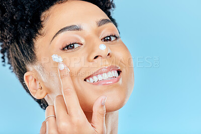 Buy stock photo Skincare, studio portrait and happy woman with cream application for self care, sunscreen protection or skin hydration. Facial routine, dermatology ointment and spa wellness person on blue background