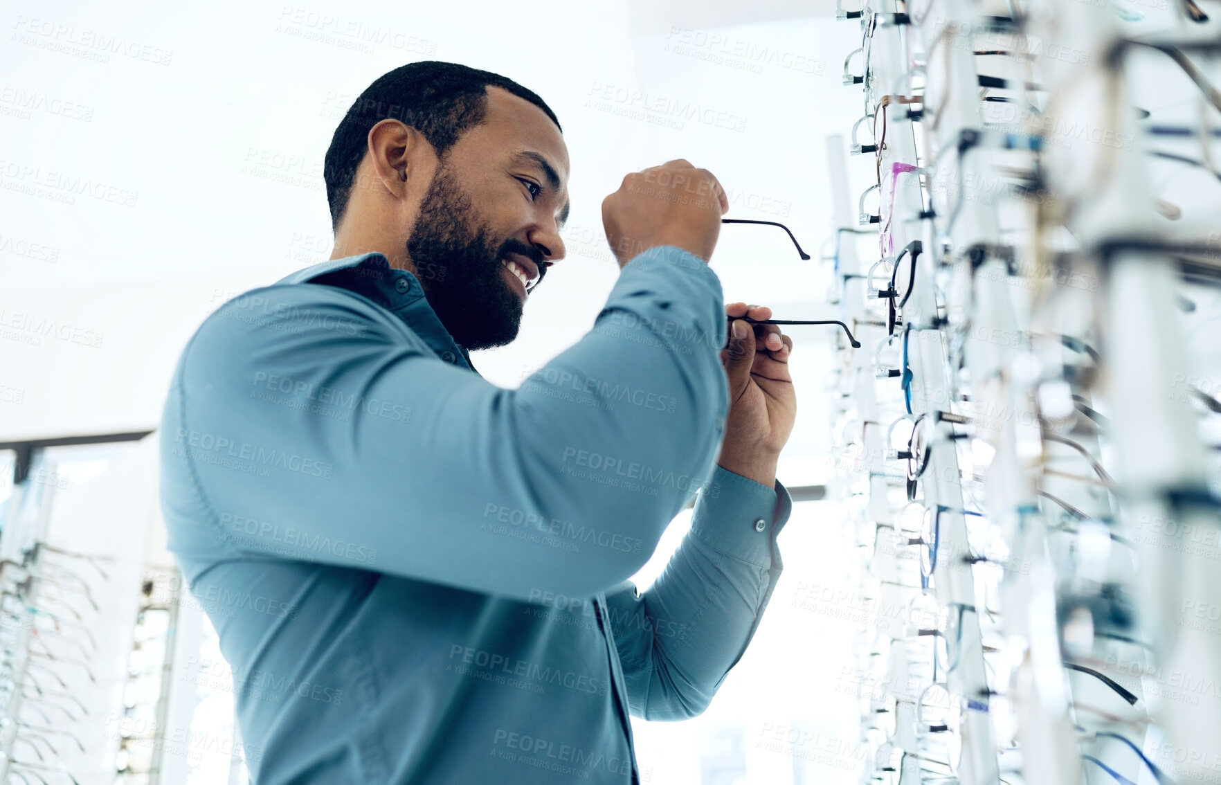 Buy stock photo Optometry, vision and happy man with glasses for decision, choice and eye care option in optician store. Healthcare, ophthalmology and person in clinic for prescription lens, spectacles and frames