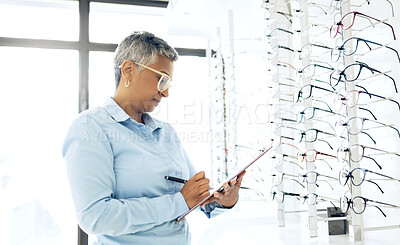 Buy stock photo Doctor, eye care or senior woman with checklist in store for retail stock, inventory or eyewear choice. Vision, ophthalmology or optician in clinic writing on clipboard for product in optometry shop