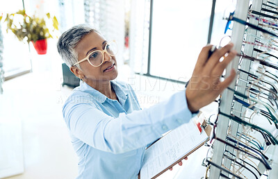 Stock, optometrist or mature woman with glasses checklist in store for retail inventory or eyewear choice. Vision, product or optician in clinic writing on clipboard for eye care in optometry shop