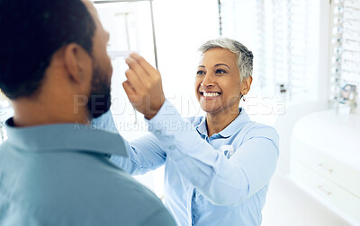 Buy stock photo Woman optometrist, fitting and customer in store with consultation for helping health and vision. Happy client, optician and eye care equipment with appointment, prescription glasses and reading