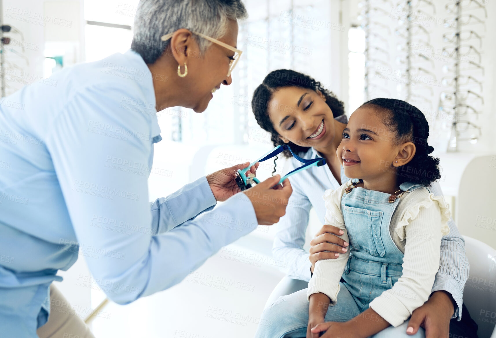 Buy stock photo Optical, glasses and optometrist with child and mother at an eye care appointment for test. Health, wellness and senior optician with young mom and girl kid patient with lenses in an optometry clinic