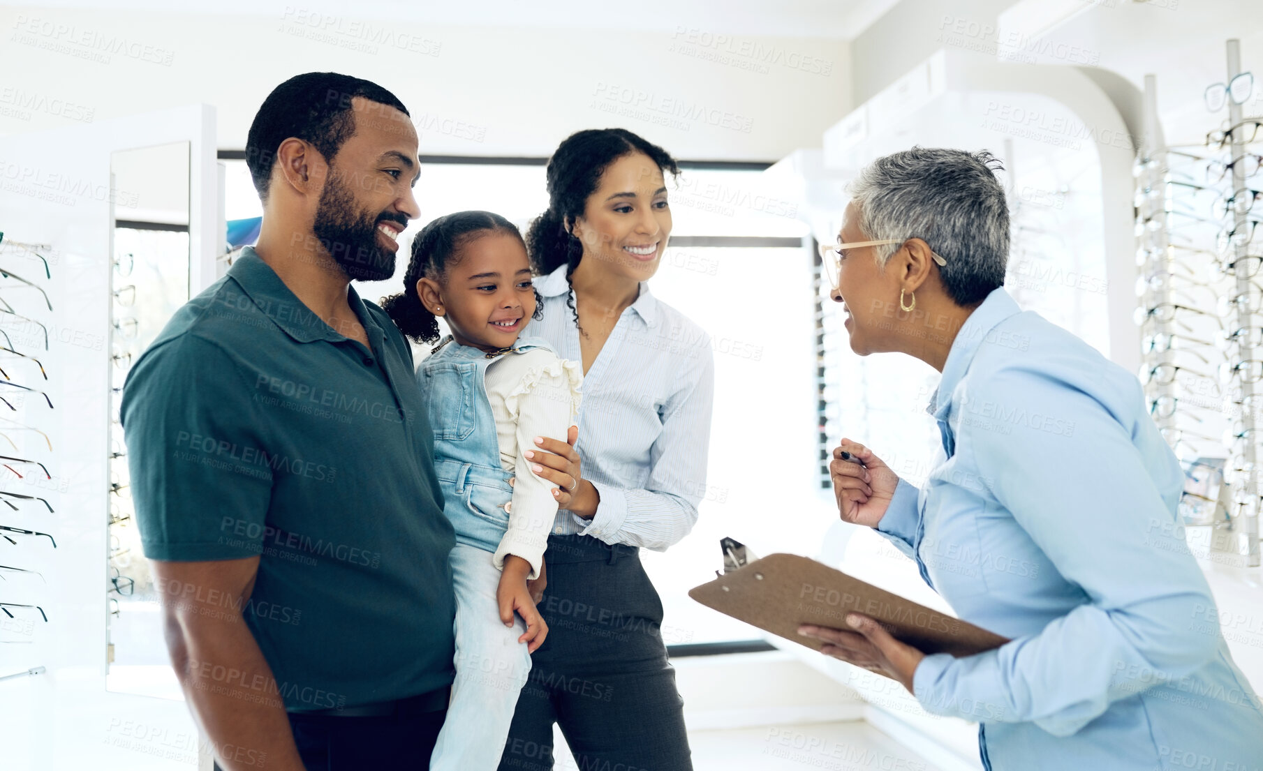 Buy stock photo Family, optometry and eye care with a woman optometrist in a clinic to see a patient for vision assessment. Mother, father and daughter at the optician for an appointment to test eyesight for kids