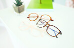 Glasses, vision and choice, optometry and frame with prescription lens on table, display and eye care. Designer, fashion and eyewear, health and product closeup, service and ophthalmology background