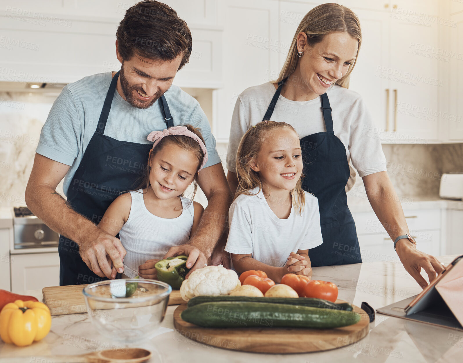 Buy stock photo Happy, cooking and family in the kitchen together for bonding and preparing dinner, lunch or supper. Love, smile and girl children cutting vegetables or ingredients with parents for a meal at home.