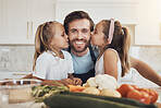 Portrait, family and kiss on the cheek from girl kids with their father in the kitchen of a home for cooking together. Face, smile and sisters with their happy parent in the house to make a meal