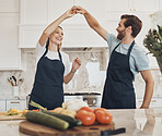 Cooking, dance or happy couple in celebration with food for a healthy vegan diet together at home. Holding hands, vegetables or woman bonding in kitchen for dinner with love, smile or man at dinner