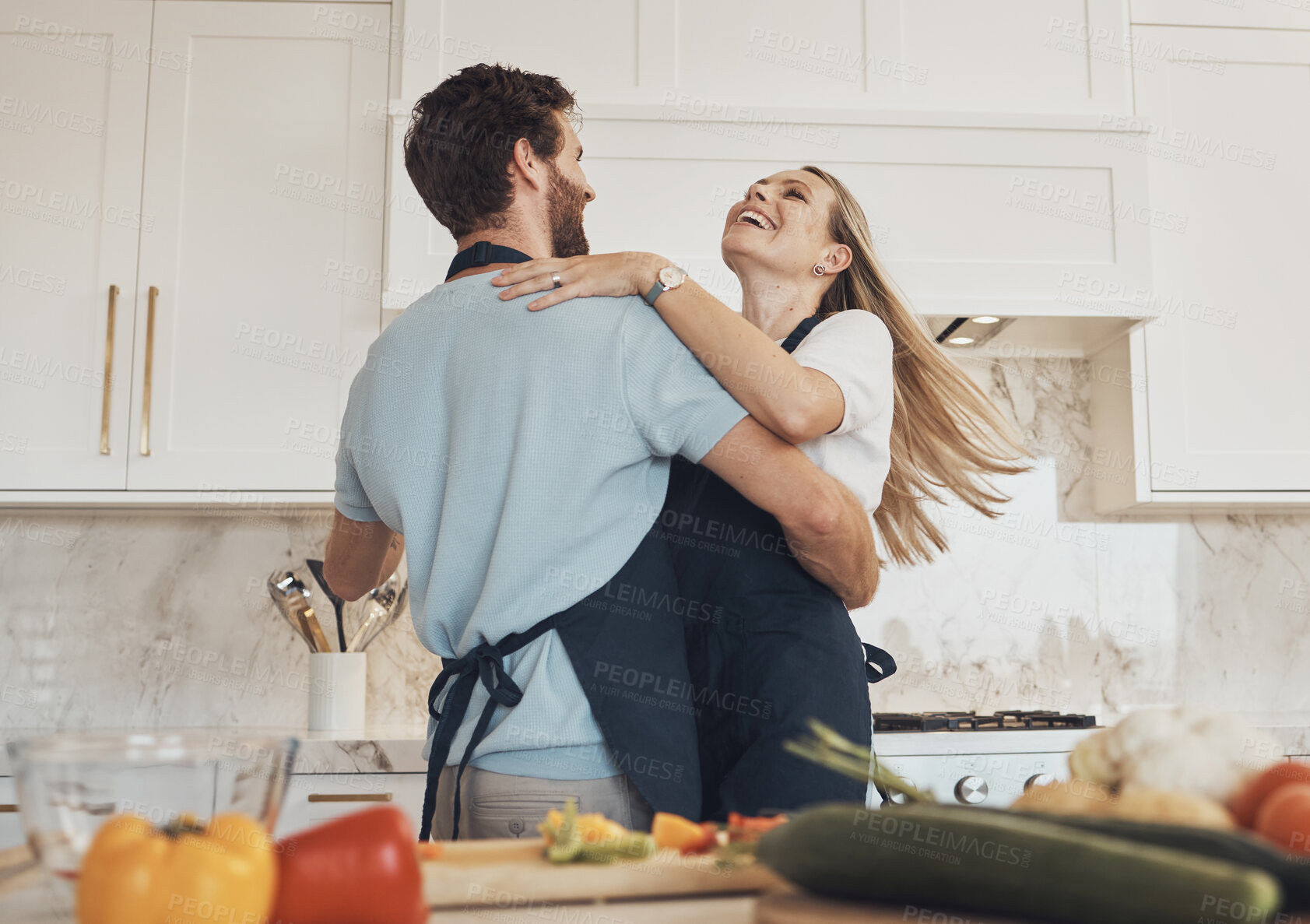 Buy stock photo Cooking, dancing or happy couple in celebration with food for a healthy vegan diet together at home. Hug, vegetables or excited woman bonding in kitchen for dinner with love, smile or romantic man