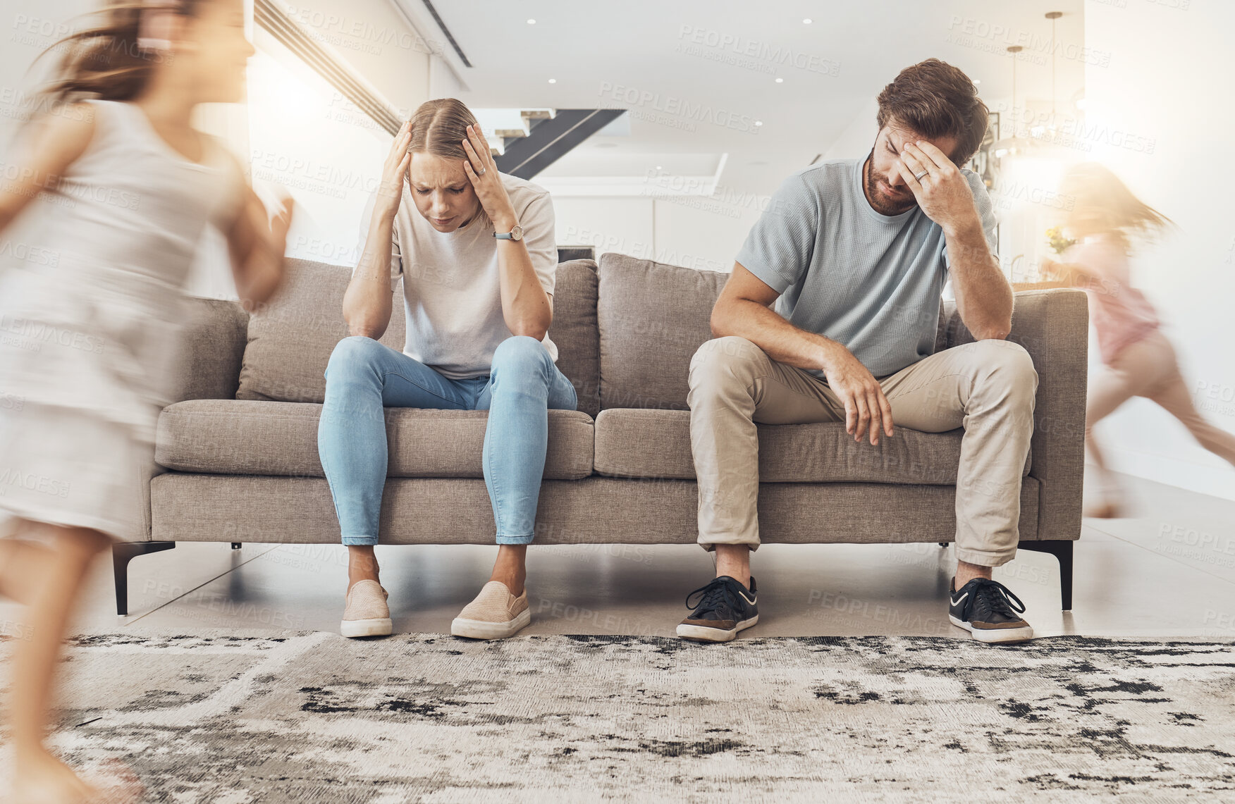 Buy stock photo Frustrated parents, sofa and headache with children running in living room chaos, ADHD or crazy home. Mother and father in stress, burnout or fatigue with busy or hyper active kids in lounge at house