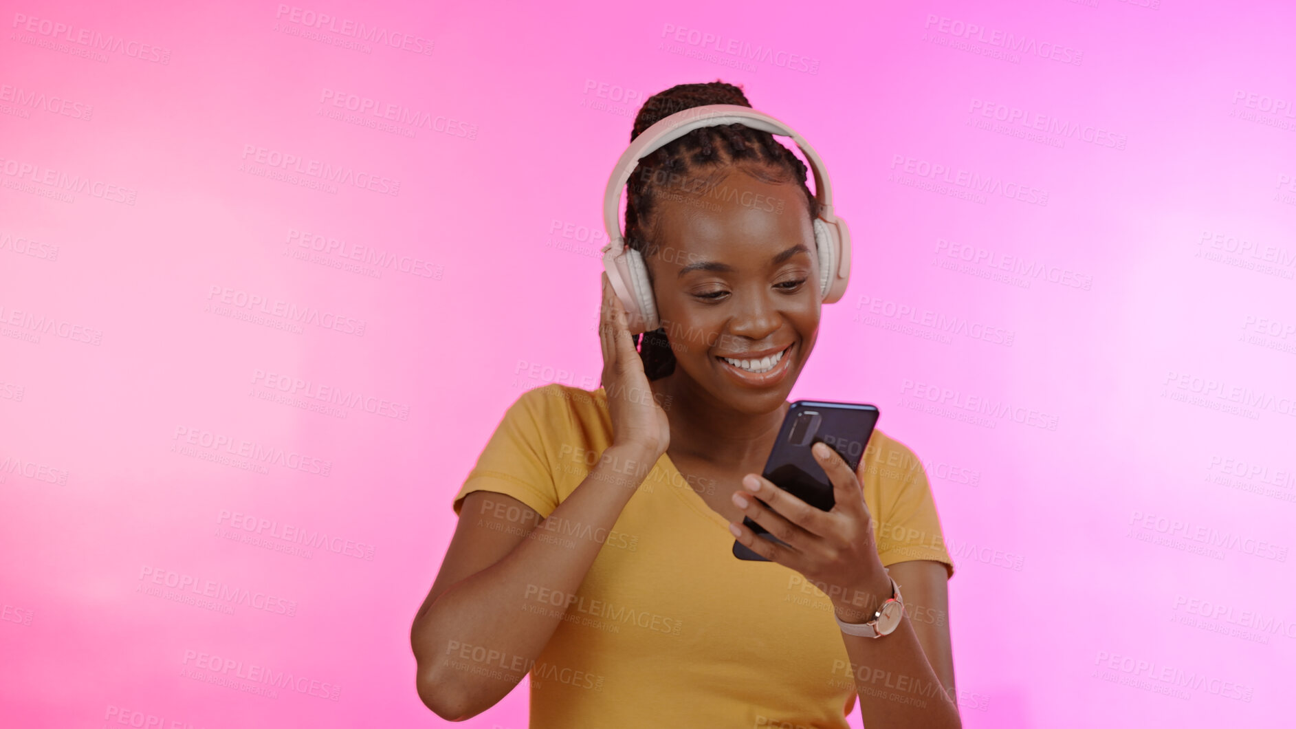 Buy stock photo Happy, headphones and black woman with a smartphone, streaming music and excited on a pink studio background. African person, model or girl with a headset, smile and cellphone with audio or listening