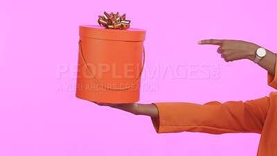 Buy stock photo Closeup, hands and person with a gif boxt, pointing and celebration on a pink studio background. Zoom, girl and model with a present, showing or package with promotion, choice or mockup space