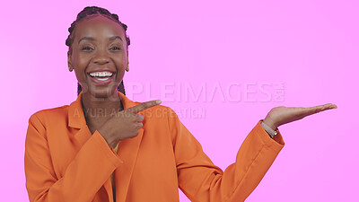 Buy stock photo Black woman, pointing and advertising in studio on empty hand, palm or mock up space. Portrait, happy or person with promotion for business, marketing or offer and presentation on pink background