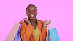 Happy woman, shopping bag and sunglasses for fashion sale, discount and giveaway or retail celebration in studio. Excited portrait of african customer in heart accessories or style on pink background